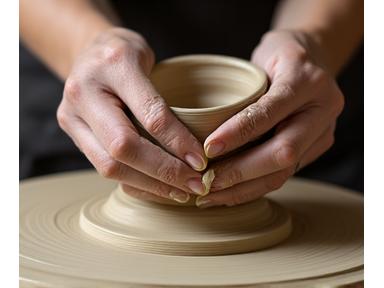 Hands shaping clay on a pottery wheel, focus on texture and movement